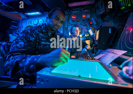 CORAL SEA (July 6, 2013) Air Traffic Controlman 2nd Class Timothy Wallace, left, and Air Traffic Controlman 2nd Class Clayton Alexander, assigned to the amphibious assault ship USS Bonhomme Richard (LHD 6), observe radar signatures in the ship's air traffic control room. Bonhomme Richard is the flagship of the Bonhomme Richard Amphibious Ready Group and, with the embarked 31st Marine Expeditionary Unit (31st MEU) is conducting routing joint-force operations in the U.S. 7th Fleet Area of Responsibility. Stock Photo