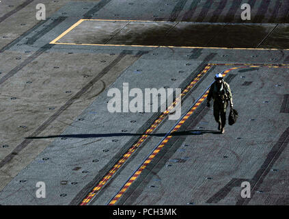 OCEAN (Nov. 30, 2016) A Sailor walks across the flight deck of the aircraft carrier USS Nimitz (CVN 68). The ship is currently underway conducting Tailored Ship's Training Availability and Final Evaluation Problem (TSTA/FEP), which evaluates the crew on their performance during training drills and real-world scenarios. Once Nimitz completes TSTA/FEP they will begin Board of Inspection and Survey (INSURV) and Composite Training Unit Exercise (COMPTUEX) in preparation for an upcoming 2017 deployment. Stock Photo