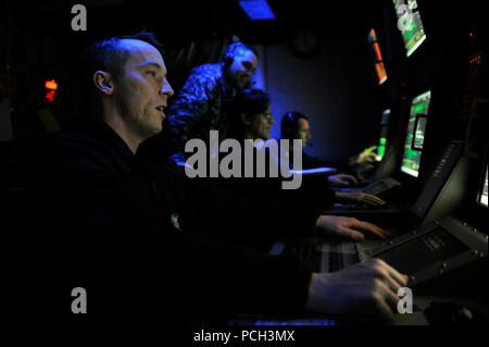 U.S. 5TH FLEET AREA OF RESPONSIBILITY (Jan. 26, 2013) Sonar Technician (Surface) 1st Class Andrew Sorenson, left, and other Sailors stand watch in the sonar control room aboard the guided-missile destroyer USS Jason Dunham (DDG 109). Jason Dunham is deployed with the John C. Stennis Strike Group to the U.S. 5th Fleet area of responsibility conducting maritime security operations, theater security cooperation efforts and support missions for Operation Enduring Freedom. Stock Photo