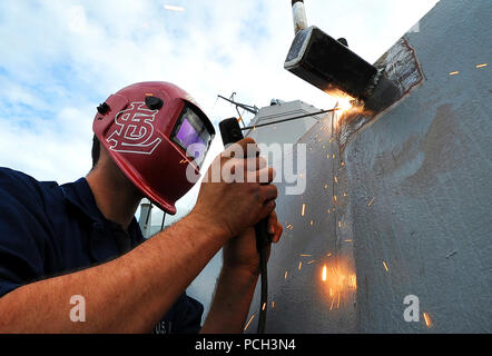 NORFOLK (Nov. 1, 2012) Hull Technician 2nd Class Deven C. Christianer performs shielded-metal arc welding on the starboard bridge wing radar mount of the San Antonio-class amphibious transport dock ship USS Mesa Verde (LPD 19). Stock Photo