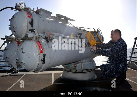 U.S. 5TH FLEET AREA OF RESPONSIBILITY (Feb. 16, 2013) Sonar Technician (Surface) 1st Class Andrew Sorenson attaches a torpedo tester to a MK 32 surface vessel torpedo tube during maintenance aboard the guided-missile destroyer USS Jason Dunham (DDG 109). Jason Dunham is deployed with the John C. Stennis Carrier Strike Group to the U.S. 5th Fleet area of responsibility conducting maritime security operations, theater security cooperation efforts and support missions for Operation Enduring Freedom. Stock Photo