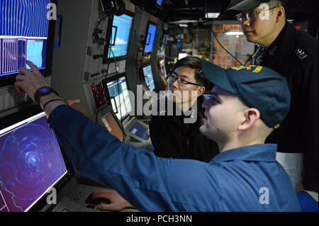 WATERS TO THE WEST OF THE KOREAN PENINSULA (March 16, 2013) Sonar Technician (Surface) 1st Class Andrew Murphy works with Republic of Korea Navy line officers in the sonar control room of the guided-missile destroyer USS McCampbell (DDG 85) during an anti-submarine warfare exercise. McCampbell is part of Destroyer Squadron 15, forward deployed to Yokosuka, Japan, and is underway to conduct exercise Foal Eagle 2013 with the Republic of Korea in support of regional security and stability of the Asia-Pacific region. Stock Photo