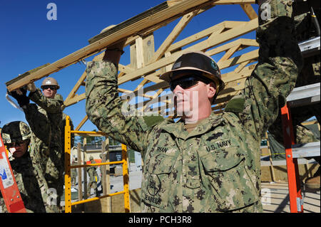 CAMP SHELBY, Miss. (Feb. 17, 2013) Builder 1st Class Lincoln Ryan assigned to Naval Mobile Construction Battalion (NMCB) 15, helps remove the A-frame from a sea hut during a final evaluation problem (FEP) before deployment. FEP is used to train and evaluate Seabees on various scenarios they may face. NMCB-15 is mobilized supporting Operation Enduring Freedom and is an expeditionary element of U.S. Naval Forces that act as combat engineers and supports various units worldwide through national force readiness, humanitarian assistance, and building and maintaining infrastructure. Stock Photo
