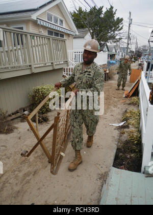 BREEZY POINT, N.Y. (Nov. 10, 2012) Builder 2nd Class Darcus Coleman, assigned to Naval Mobile Construction Battalion (NMCB) 5, removes items from a home that was damaged during Hurricane Sandy. Stock Photo