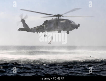 ARABIAN SEA (Feb. 7, 2012) A search and rescue swimmer assigned to the guided-missile cruiser USS Bunker Hill (CG 52) is deployed from an SH-60B Sea Hawk helicopter during search and rescue training. Bunker Hill is deployed to the U.S. 5th Fleet area of responsibility conducting maritime security operations and theater security operation efforts. Stock Photo