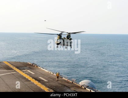 A U.S. Army CH-47F Chinook helicopter assigned to the 3rd General Support Aviation Battalion, 2nd Combat Aviation Brigade, 2nd Infantry Division prepares to land aboard the amphibious assault ship USS Bonhomme Richard (LHD 6) in the East China Sea April 11, 2014. The Bonhomme Richard was underway in the U.S. 7th Fleet area of responsibility supporting maritime security operations and theater security cooperation efforts. Stock Photo