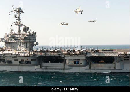 A U.S. Navy E-2C Hawkeye aircraft flown by Cmdr. John Hewitt, top, the outgoing commanding officer of Carrier Airborne Early Warning Squadron (VAW) 126, an E-2C flown by Cmdr. Przemyslaw Kaczynski, left, the squadron's incoming commanding officer, and an EA-18G Growler aircraft flown by Capt. George Wikoff, the commander of Carrier Air Wing (CVW) 3, participate in an aerial change of command ceremony over the aircraft carrier USS Harry S. Truman (CVN 75) March 18, 2014, in the Gulf of Oman. The Harry S. Truman Carrier Strike Group was deployed to the U.S. 5th Fleet area of responsibility suppo Stock Photo