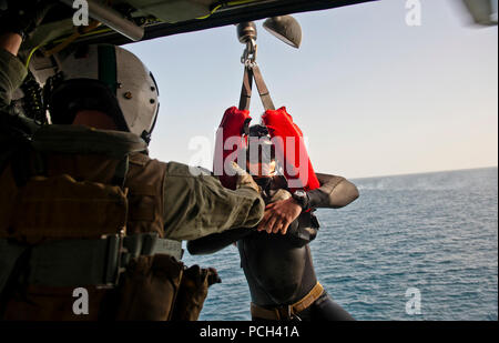 A U.S. Navy explosive ordnance disposal technician is hoisted to an MH-60S Knighthawk helicopter from Helicopter Strike Squadron (HSC) 8 attached to aircraft carrier USS John C. Stennis (CVN 74) Jan. 17, 2012, in the Arabian Sea. Stennis was deployed to the U.S. 5th Fleet area of responsibility to conduct maritime security operations and support missions as part of Operation Enduring Freedom. Stock Photo