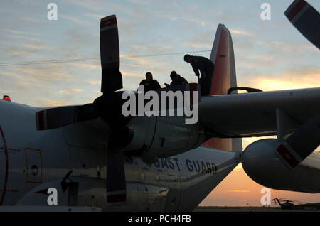 Coast Guard flight crew, from Coast Guard Air Station Clearwater, work on the wing of a HC-130 H performing maintenance before an upcoming flight on U.S. Naval Station Guantanamo Bay airfield, Jan. 19. The aircrew is deployed in support of Operation Unified Response, providing humanitarian assistance to Haiti. Stock Photo