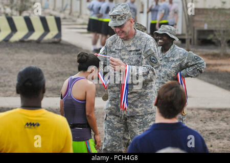 CAMP LEMONNIER, Djibouti (Sept. 21, 2013) Army Maj. Gen. Terry, commander, Combined Joint Task Force - Horn of Africa, presents Air force Maj. Christina Perez with a medal at the finish line of the Air Force Half Marathon and 10K combined races on Camp Lemonnier, held in honor of the Air Force's 66th birthday. Perez finished in second place for the women's category of the half-marathon, with a time of 1:53:21. Stock Photo