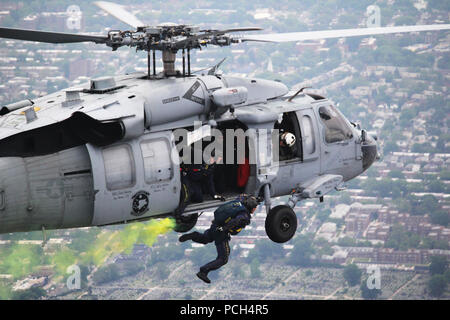 YORK (May 30, 2016) Aircrew Survival Equipmentman 1st Class Victor Maldonado, member of the Navy Parachute Team, the Leap Frogs, jumps out of an MH-60S Seahawk helicopter from the Fleet Angels of HSC-2 during a skydiving demonstration above Citi Field before a New York Mets baseball game. Stock Photo