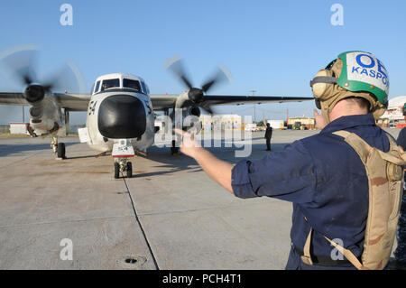 Navy Petty Officer 3rd Class Andrew Kaspor, an aviation electricians mate, marshals the start-up of an engine on a C-2 Greyhound aircraft at U.S. Naval Station Guantanamo Bay, Jan. 24. The aircraft, scheduled to fly missions to Haiti, is here in support of Operation Unified Response. Stock Photo