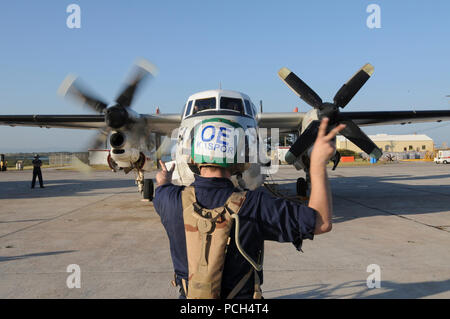 Navy Petty Officer 3rd Class Andrew Kaspor, an aviation electricians mate, marshals the start-up of an engine on a C-2 Greyhound aircraft at U.S. Naval Station Guantanamo Bay, Jan. 24. The aircraft, scheduled to fly missions in Haiti, is here in support of Operation Unified Response. Stock Photo