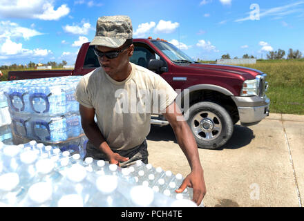 (September 2, 2012) .BELLE CHASSE - Airman 1st Class Johnny L. Carter, 159th Medical Group, Louisiana Air National Guard, grabs a case of water as members of the Louisiana National Guard distribute water, ice and MREs to citizens in need at the Belle Chasse point of distribution, Sept. 2, 2012. The Louisiana National Guard has more than 6,000 Soldiers and Airmen ready to support citizens, local and state authorities in support of Hurricane Isaac operations.  (US Navy Stock Photo