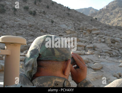 Police mentors and the security forces assigned to protect them roll into Ala Sai along with the Afghan national army and Afghan national police to track down Taliban fighters.  Staff Sgt. Vili Schwenke, South Carolina National Guard, scans the ridge line for any movement during a security halt. Stock Photo