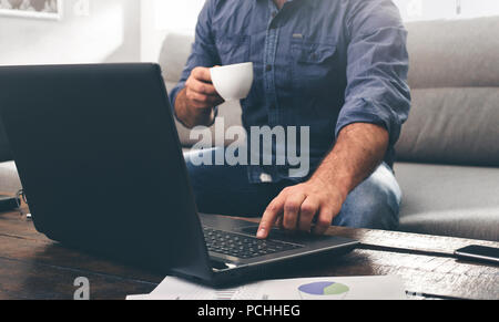 Work at home concept. Businessman works laptop on the sofa at home Stock Photo