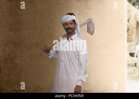 Portrait of Indian farmer carrying hoe on his shoulder Stock Photo