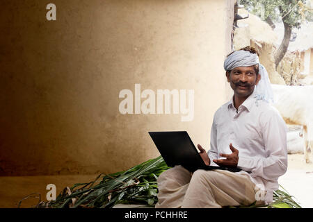 Indian rural farmer using laptop Stock Photo