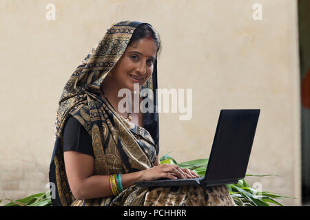 Rural woman using laptop Stock Photo