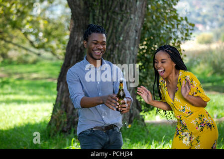 Couple popping a bottle of champagne Stock Photo