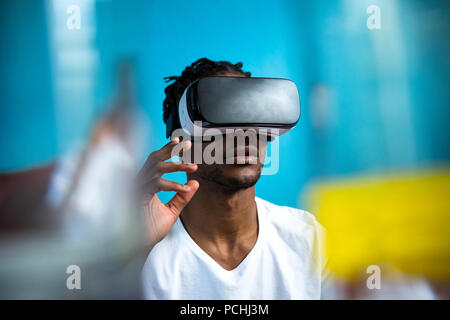 African man looking through VR headset Stock Photo