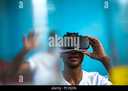 African man looking through VR headset Stock Photo