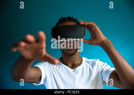 African man looking through VR headset Stock Photo