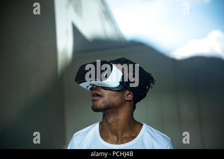 African man looking through VR headset Stock Photo
