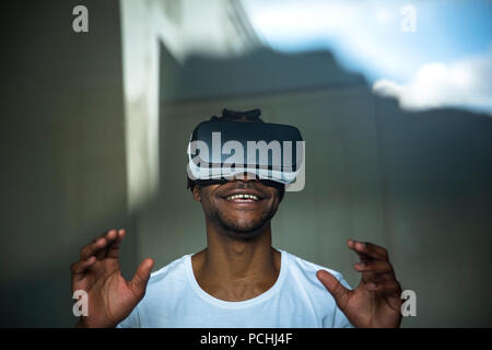 African man looking through VR headset Stock Photo