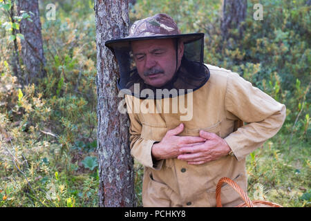 Senior caucasian man having heart attack in park while walking alone. Stock Photo