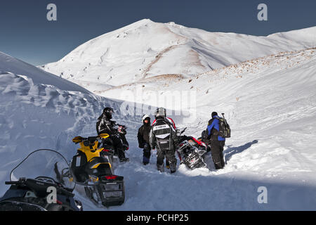 Men dig snowmobile. Russia, Adygea, Lago-Naki plateau, February 2, 2012. Stock Photo