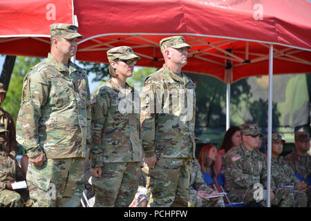 From left to right, the 44th Expeditionary Signal Battalion (44th ESB) outgoing Command Sgt. Maj. Chad S. Yeager, the 44th ESB commander U.S. Army Lt. Col. Heather McAteer, and the 44th ESB incoming Command Sgt. Maj. Sean P. Mitcham, stand in front of the formation during battalion’s change of responsibility ceremony at Tower Barracks, Grafenwoehr, Germany, July 27, 2018. (U.S. Army photo by Gertrud Zach) Stock Photo