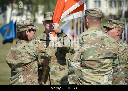 The 44th Expeditionary Signal Battalion Commander U.S. Army Lt. Col. Heather McAteer, left, passes the unit colors to Command Sgt. Maj. Sean P. Mitcham, second from left, during the battalion’s change of responsibility ceremony at Tower Barracks, Grafenwoehr, Germany, July 27, 2018. (U.S. Army photo by Gertrud Zach) Stock Photo