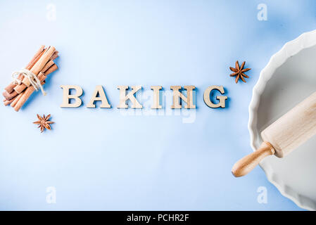 Baking concept with white baking dish, rolling pin, spice for baking, on a light blue background, top view copy space Stock Photo