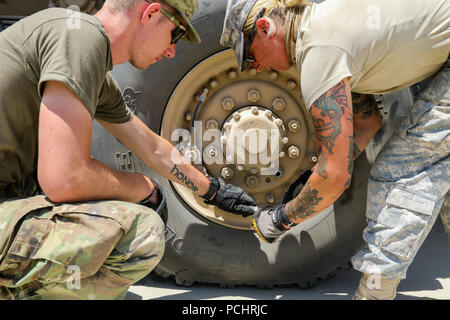 Soldiers with 41st Infantry Brigade Combat Team's 2nd Battalion, 218th Field Artillery perform maintenance operations on their vehicles to prepare for their road march July 27, 2018 during a field training exercise known as eXportable Combat Training Capability (XCTC) at Fort Irwin, California. The exercise is an instrumented brigade field training exercise designed to certify platoon proficiency across the brigade in coordination with First Army. “This exercise keeps our units trained and ready for federal missions and builds upon the brigade’s training from last year’s Warfighter Exercise,”  Stock Photo