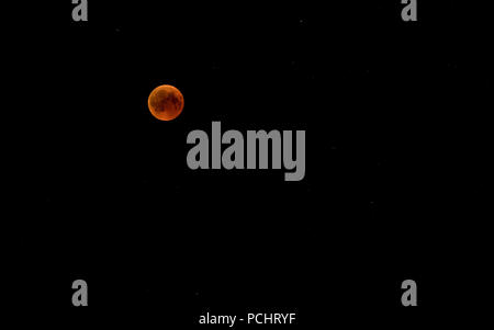 Blood moon is a term used to describe the Moon’s reddish appearance during a total lunar eclipse caused by sunlight refracted through Earth’s atmosphere. On July 27–28, 2018, a total lunar eclipse visible over Iraq produced this effect as the Moon set in the early morning sky. The archival image records the eclipse phase with the Moon low on the horizon. Stock Photo