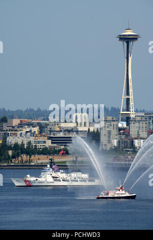 The crew of the Coast Guard Cutter Mellon, a 378-foot High Endurance Cutter home-ported in Seattle, sails past the Seattle Fire Department Boat Leschi and the Seattle Space Needle during the annual Parade of Ships in Seattle, July 31, 2018.    The Parade of Ships is part of the annual Seattle Seafair air and sea events held each summer in the Seattle area.    U.S. Coast Guard photo by Chief Petty Officer David Mosley Stock Photo