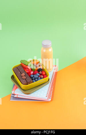 Delicious Dutch breakfast with sweet bread, berries and juice in a bottle. Food for children in school. School accessories and exercise books. Top vie Stock Photo