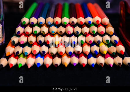 Colored Pencils stacked neatly in a random color pattern but in a very OCD fashion ready for use by students or artists.  A Macro image from a head on Stock Photo