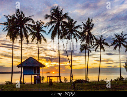 tropical sunrise behind palm trees over the Gulf of Thailand, Sanamwan beach Stock Photo