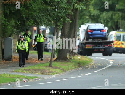 Police officers near the scene on Bingley Road at the junction with Toller Lane in Bradford following a road traffic collision where four males died in a car which was being followed by an unmarked police vehicle when it crashed. Stock Photo