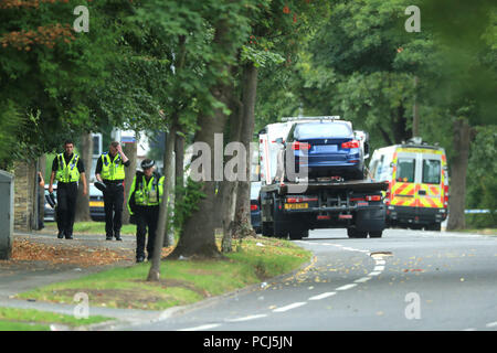 Police officers near the scene on Bingley Road at the junction with Toller Lane in Bradford following a road traffic collision where four males died in a car which was being followed by an unmarked police vehicle when it crashed. Stock Photo