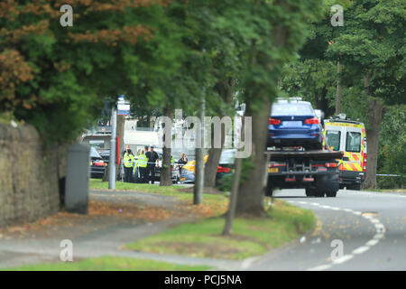 Police officers at the scene on Bingley Road at the junction with Toller Lane in Bradford following a road traffic collision where four males died in a car which was being followed by an unmarked police vehicle when it crashed. Stock Photo