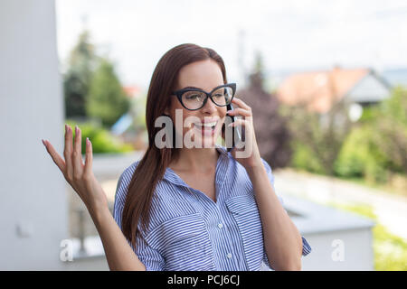 Young smart realtor woman calling and discuss outdoors Stock Photo
