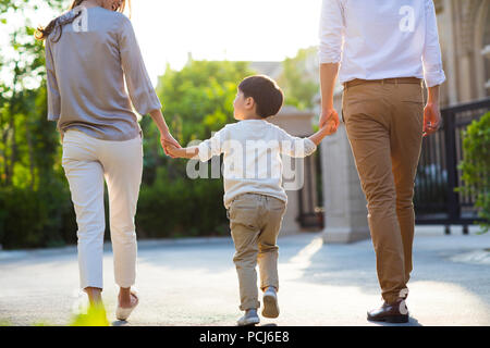 Happy young Chinese family holding hands walking Stock Photo