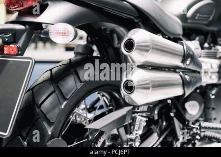 Close up shot of new motorcycle exhaust pipes. Rear view of a motorcycle with the focus on the chrome exhaust. Stock Photo