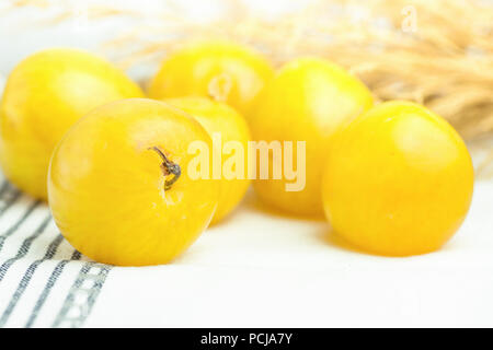 Bunch of ripe juicy organic yellow plums bouquet of dry autumn plants flowers on white cotton towel. Autumn fall Produce. Vivid Colors. Provence rural Stock Photo