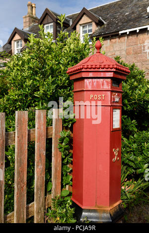 Red Royal Mail Post Office box with evergreen Hebe bush at Baile Mor village on Isle of Iona Inner Hebrides Scotland UK Stock Photo