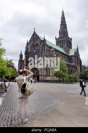 GLASGOW, SCOTLAND - AUGUST 2nd 2018: A tourist taking a photograph of Glasgow Cathedral in the Cathedral Precinct. Stock Photo