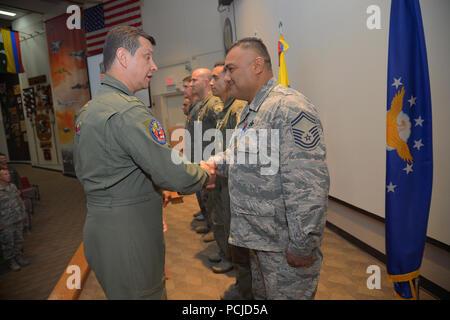 The Commander of the Colombian Air Force, General Carlos Eduardo Bueno Vargas, shakes hands with U.S. Air Force Senior Master Sgt. Roberto Vasquez, 12th Air Force (Air Forces Southern) after presenting him with the Colombian Air Force Faith in the Cause Medal during Red Flag 18-3 at Nellis Air Force Base, Nev., July 27, 2018. The Faith in the Cause Medal recognizes their commitment to the mission of the Colombian Air Force. (U.S. Air Force photo by Staff Sgt. Angela Ruiz) Stock Photo